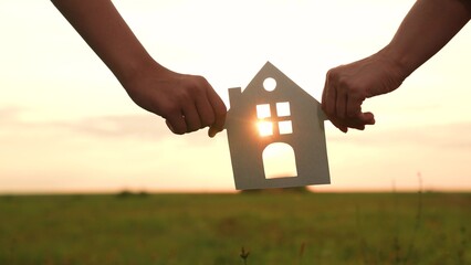 hands holding paper house, window sunset ray, happy family mortgage build new house, home buying...