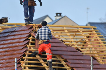 ouvrier couvreur sur un toit d'habitation  - 775623030