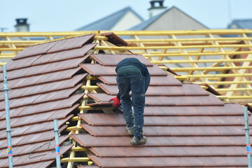 ouvrier couvreur sur un toit d'habitation  - 775623084