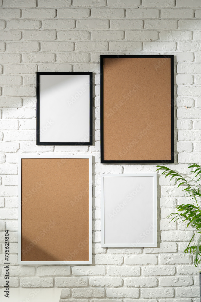 Wall mural Varied Sized Photo Frames Displayed on a White Brick Wall