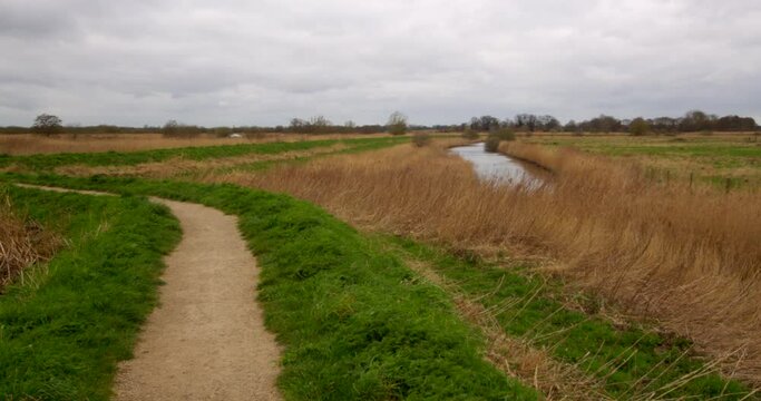 wide landscape shot of drainage ditch next to the river Bure. . At Norfolk Broads, Ludham on the river Bure