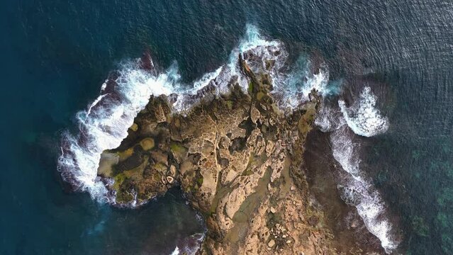 Top Down drone View Over A Rocky Shore Line with salt pans and Waves Splashing. Marsaskala, Malta.