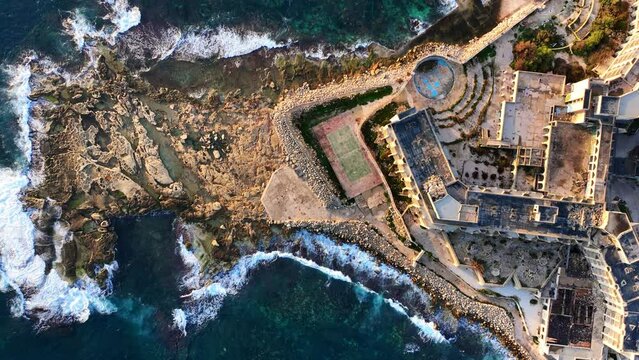 Top-down Drone shot of Abandoned Jerma Palace Hotel in Marsaskala, sunrise time, Malta.