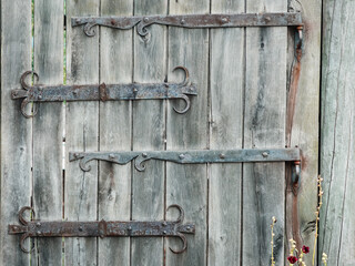 Vintage forged hinges on a wooden gate