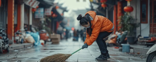 Local resident tidying up wet alley in old Chinese neighborhood. Street cleaning and urban lifestyle concept - obrazy, fototapety, plakaty