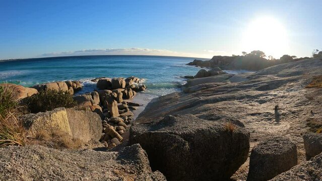 Time lapse shot of waving Water at Bay of Fires in Tasmania. Sunrise time in Australia. Rocky coastline with beautiful blue ocean in background. 