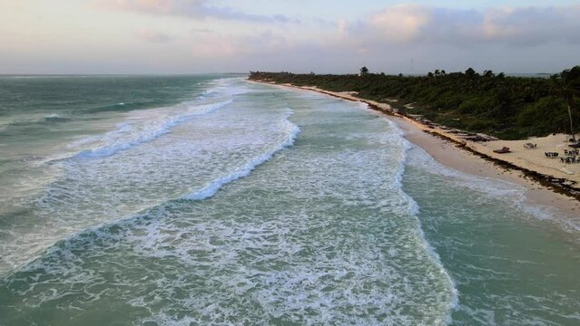 Aerial view of sea waves reaching the beach coast.