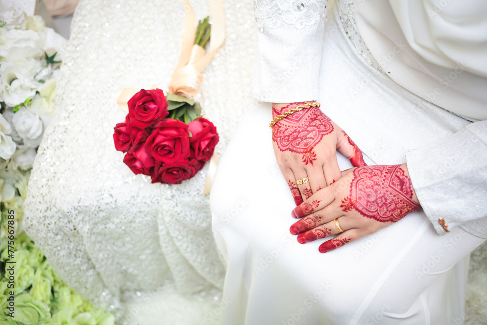 Wall mural Bride hands with henna and golden wedding rings. Malay henna art pattern.