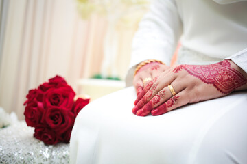 Bride hands with henna and golden wedding rings. Malay henna art pattern.