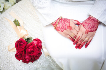 Bride hands with henna and golden wedding rings. Malay henna art pattern.