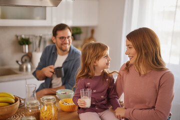 Happy family having breakfast at table in kitchen