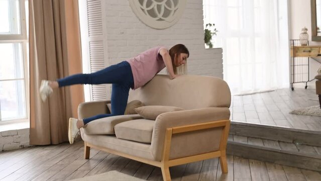 A woman has lost something and is looking for money or keys in the sofa, under the sofa and carpet