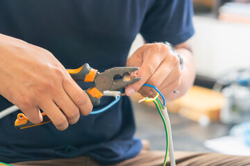 Close-up of Technician cutting electrical wires with pliers for installing new air conditioning,...