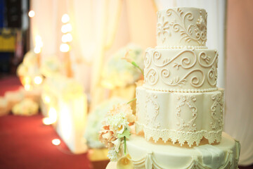 Five-tiered elegant white wedding cake decorated with flowers on a table. Wedding decoration cake. Selective focus.