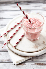 Strawberry Smoothie on bright wooden background. Close up.