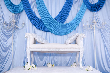 Malay wedding decor stage with flowers and chair. Wedding setup.