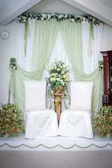 Malay wedding decor stage with flowers and chair. Wedding setup.