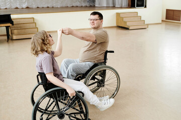 High angle view of Caucasian man and woman in wheelchairs dancing during class in studio