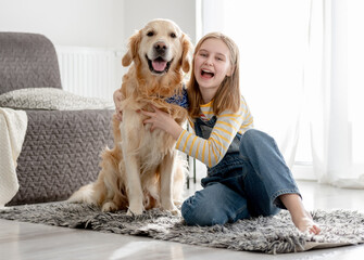 Girl With Golden Retriever Dog Poses At Home On Floor For A Portrait With Dog