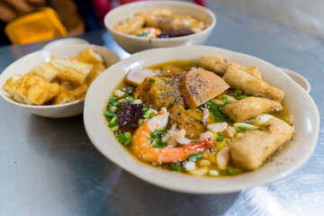 Focus on Crab Noodle Soup ('Banh Canh Cua') with bagel twists ('banh quay'), shrimp and pork...