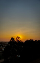 Beautiful sunset scenery view of sun hiding behind clouds, silhouette of trees, nature photography, natural scenic background, sunset wallpaper