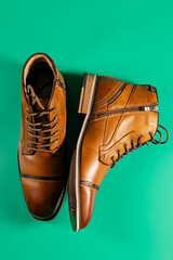 A pair of premium calfskin boots on a green background. Vertical shot.