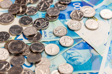 New Israeli shekel coins and bills lie on the table. Shekels. - obrazy, fototapety, plakaty