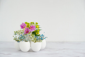Beautiful Easter composition. flowers in eggs shells on marble background. festive spring season. table decor for Easter holiday, Ostara sabbat. - obrazy, fototapety, plakaty