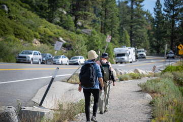 Cars parked along the busy Emerald Bay Road. People walking on the side of the road. Lake Tahoe....