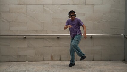 Motion shot of hipster listen music while move or dance to music at dancing room. Attractive street...