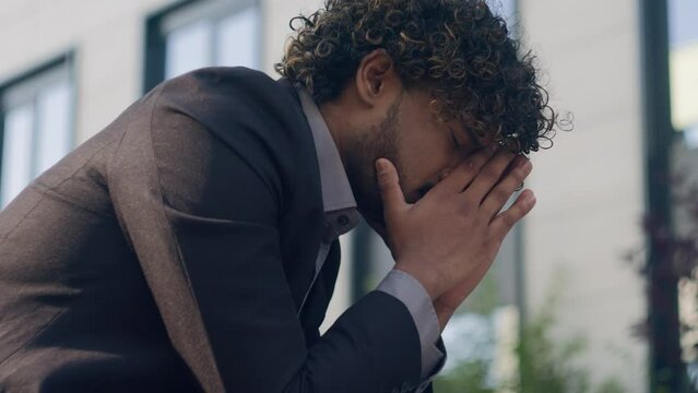 Indian business man employer anxiety business failure bankruptcy jobless businessman in city outdoors depression despair desperate displeased dramatic negative worry emotion exhausted grief headache