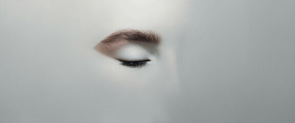 close-up of a closed eye with soft neutral background