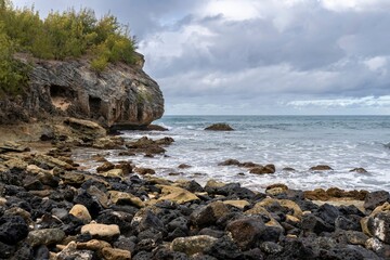 Rough Pacific Ocean waves crash onto jagged cliffs along Shipwreck Beach in Koloa, Hawaii, on the...