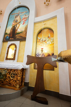 Ternopil, Ukraine- May, 2023: Franciscan cross. A warm church interior featuring intricate religious paintings, a wooden pulpit, and traditional decor. Inviting and tranquil atmosphere for worship.