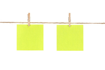 Wooden clothespins with blank notepapers on twine against isolated white background space for text....