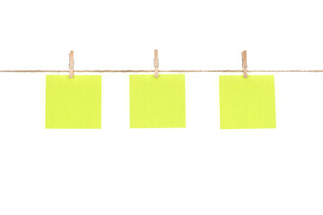 Wooden clothespins with blank notepapers on twine against isolated white background space for text. note blank color paper cards on rope. blanks for designers