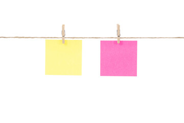Wooden clothespins with blank notepapers on twine against isolated white background space for text. note blank color paper cards on rope. blanks for designers