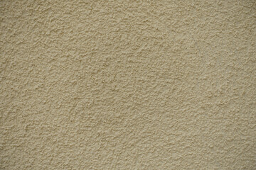 Close view of wall with coarse light beige roughcast finish