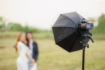 portable flash light setup with reflector modifier for portrait lighting outdoor photography - obrazy, fototapety, plakaty