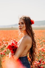Naklejka premium Woman poppies field. portrait happy woman with long hair in a poppy field and enjoying the beauty of nature in a warm summer day.
