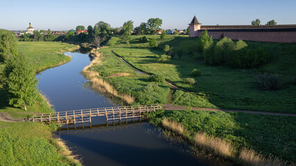 Aerial view of a wooden bridge over a small river, late spring in Suzdal, Russia 