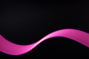 Pink and purple neon glowing wave of light with dotted stripes on black background. Abstract background with motion light effect, light painting in disco party style.
