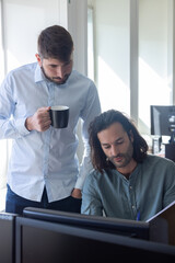 deux collègues, jeunes employés de bureau travaillent en équipe et discutent assis devant un...