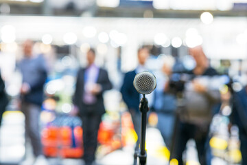 Microphone in focus against blurred people. Public relations - PR concept.