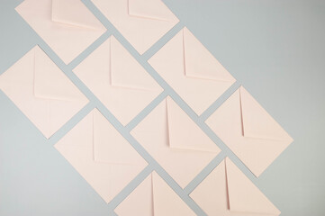 Top view of pink envelopes on grey background. Post flat lay. Copy space.