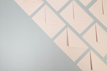 Top view of pink envelopes on grey background. Post flat lay. Copy space.