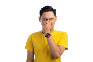 Handsome Asian man pinching his nose with fingers, smelling something smelly and disgusting isolated on white background