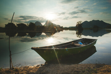 Fisherman boat on the beautiful lake in the morning. Sunrise view.