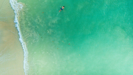 Aerial view of person swimming in transparent sea on Kapas Island on Kuala Terengganu, Malaysia.