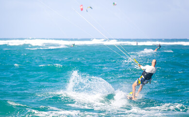 Kiteboarding. Fun in the ocean. Extreme Sport Kitesurfing. Kitesurfer jumping high in the air performing triks during kitesurfing session